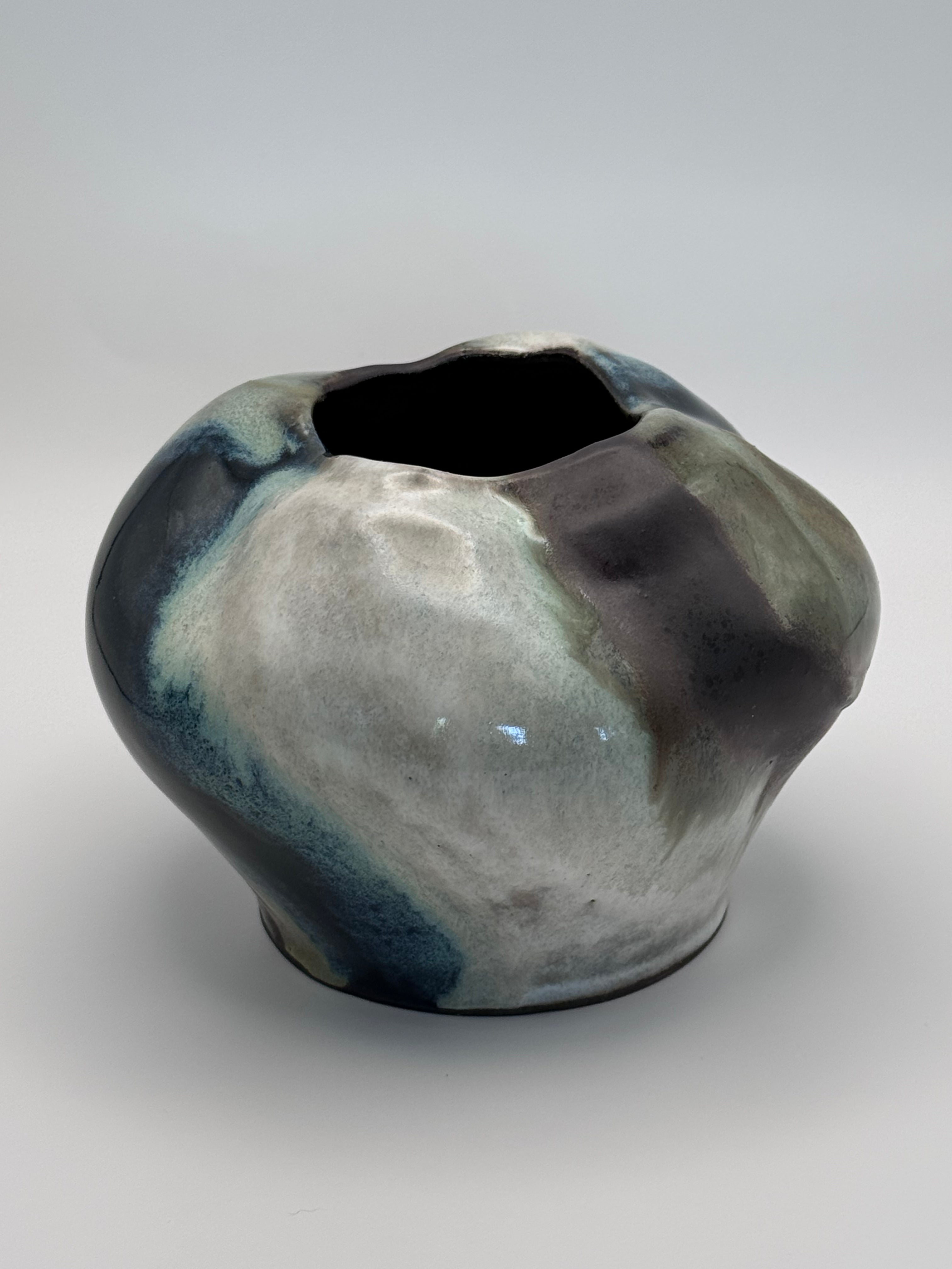 Ceramic vase with a full round body and irregular petal-like opening, marbled dark brown, white, green celadon, and light blue glaze. View 2 of 3