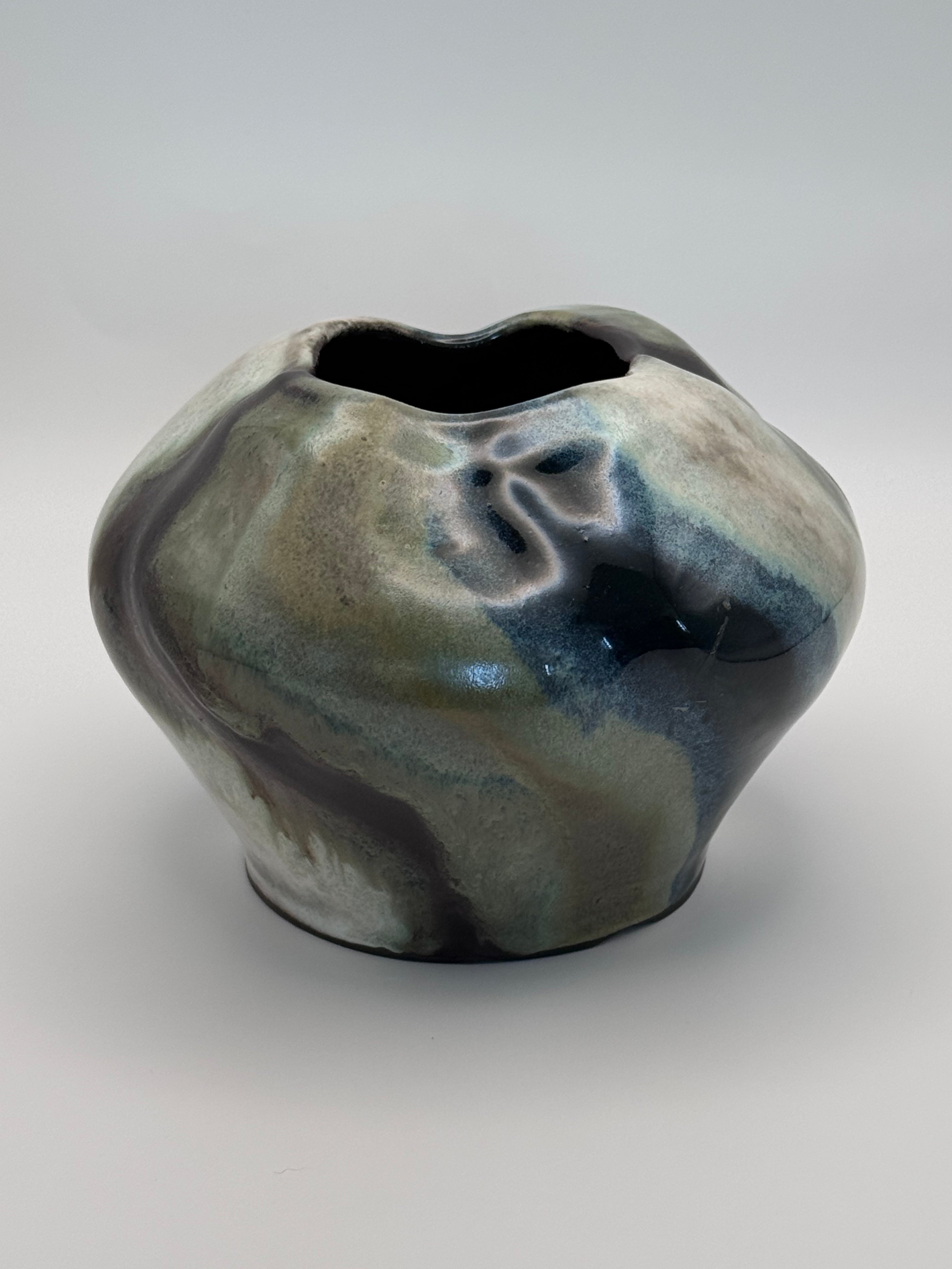 Ceramic vase with a full round body and irregular petal-like opening, marbled dark brown, white, green celadon, and light blue glaze. View 3 of 3