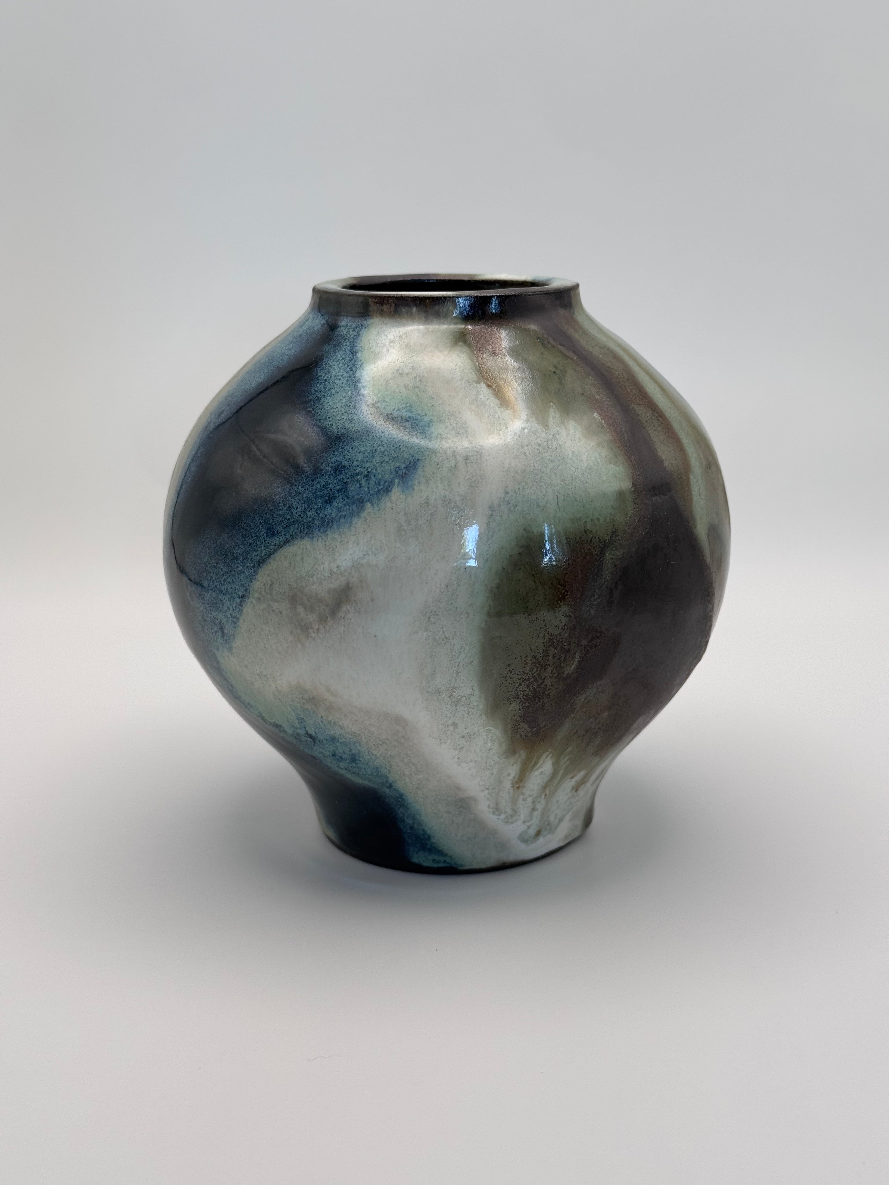 Round ceramic vase with a narrow mouth, marbled dark brown, white, green celadon, and light blue glaze.