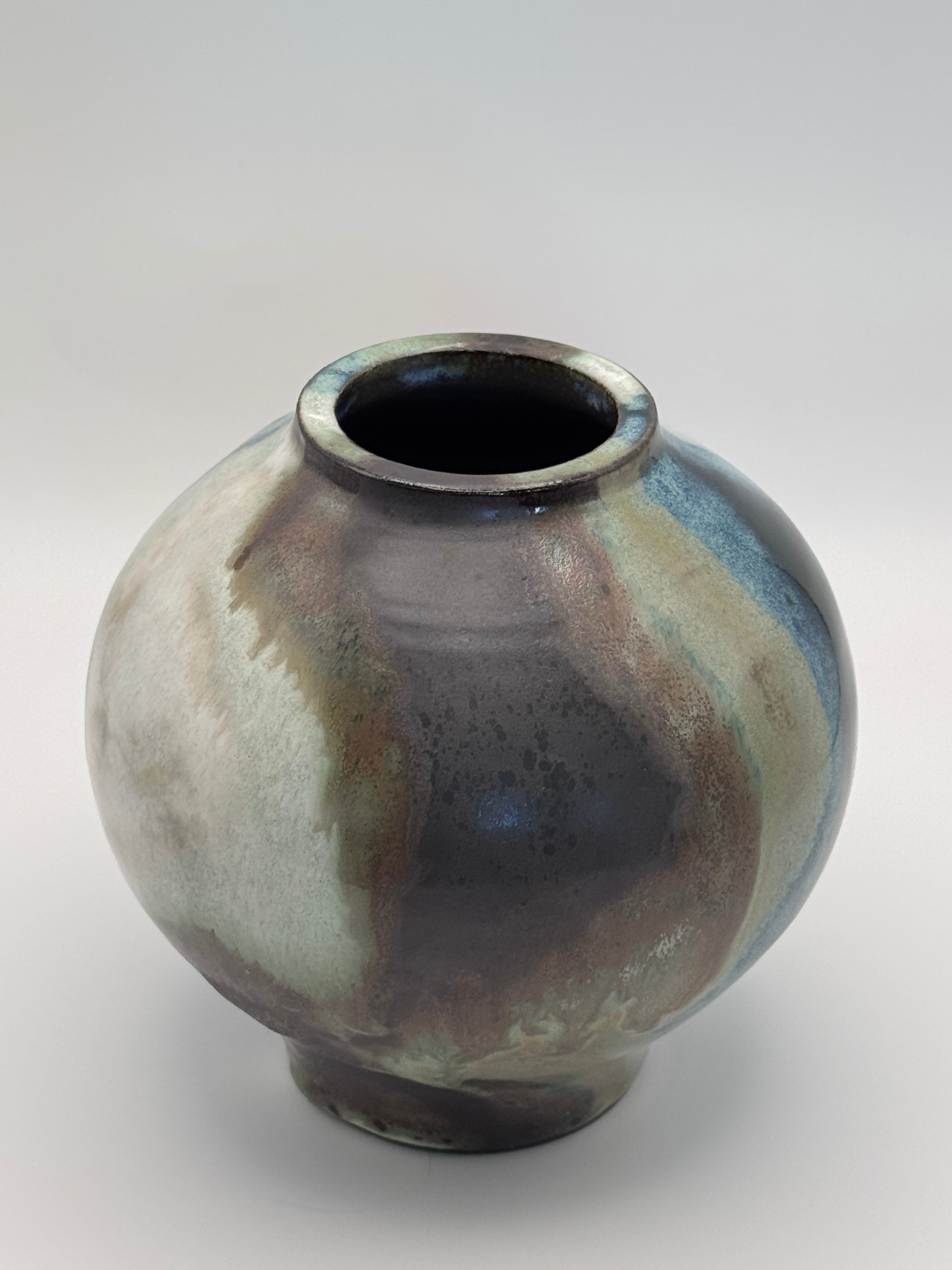 Top view of Round ceramic vase with a narrow mouth, marbled dark brown, white, green celadon, and light blue glaze.