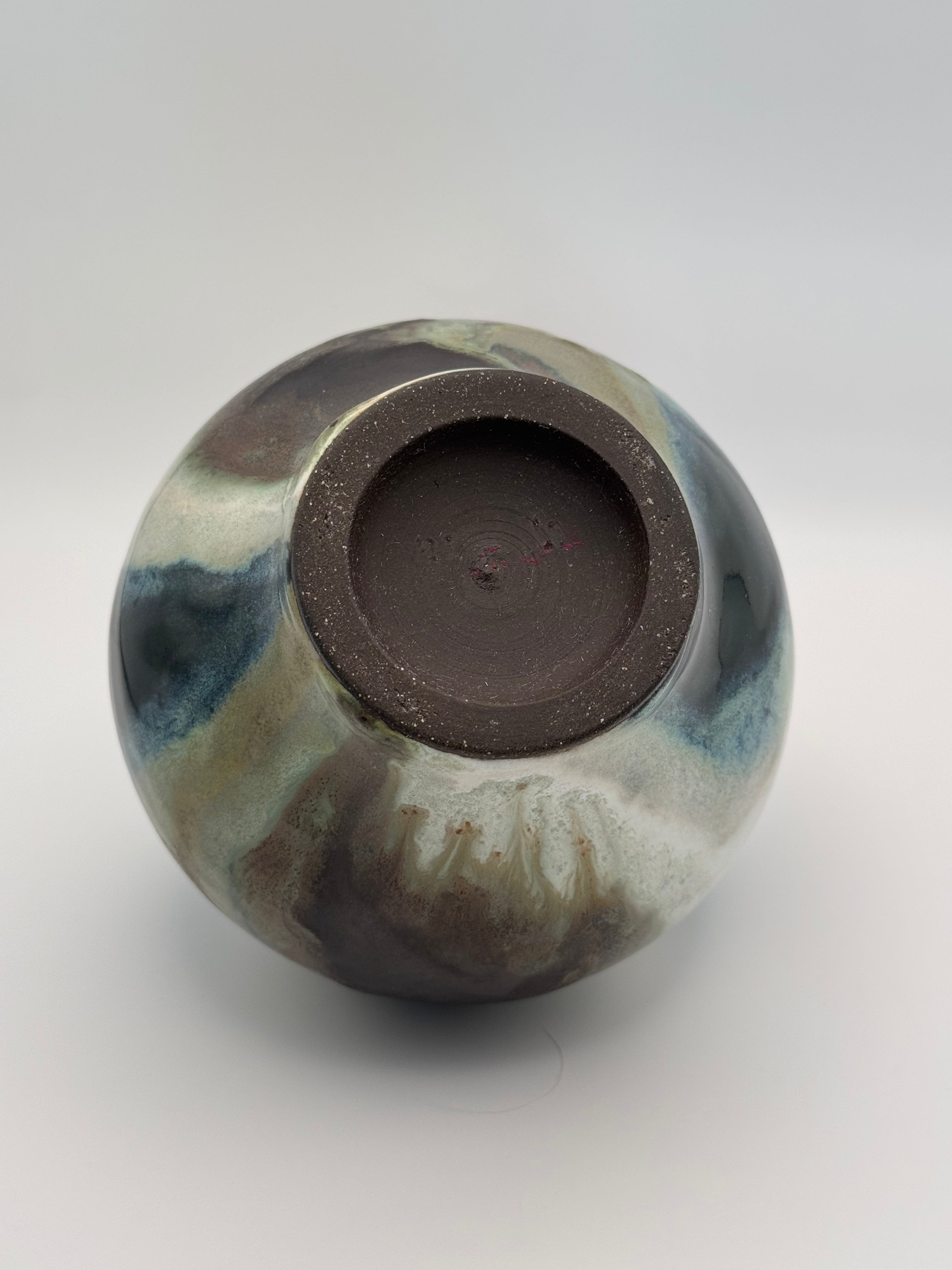 foot of Round ceramic vase with a narrow mouth, marbled dark brown, white, green celadon, and light blue glaze.