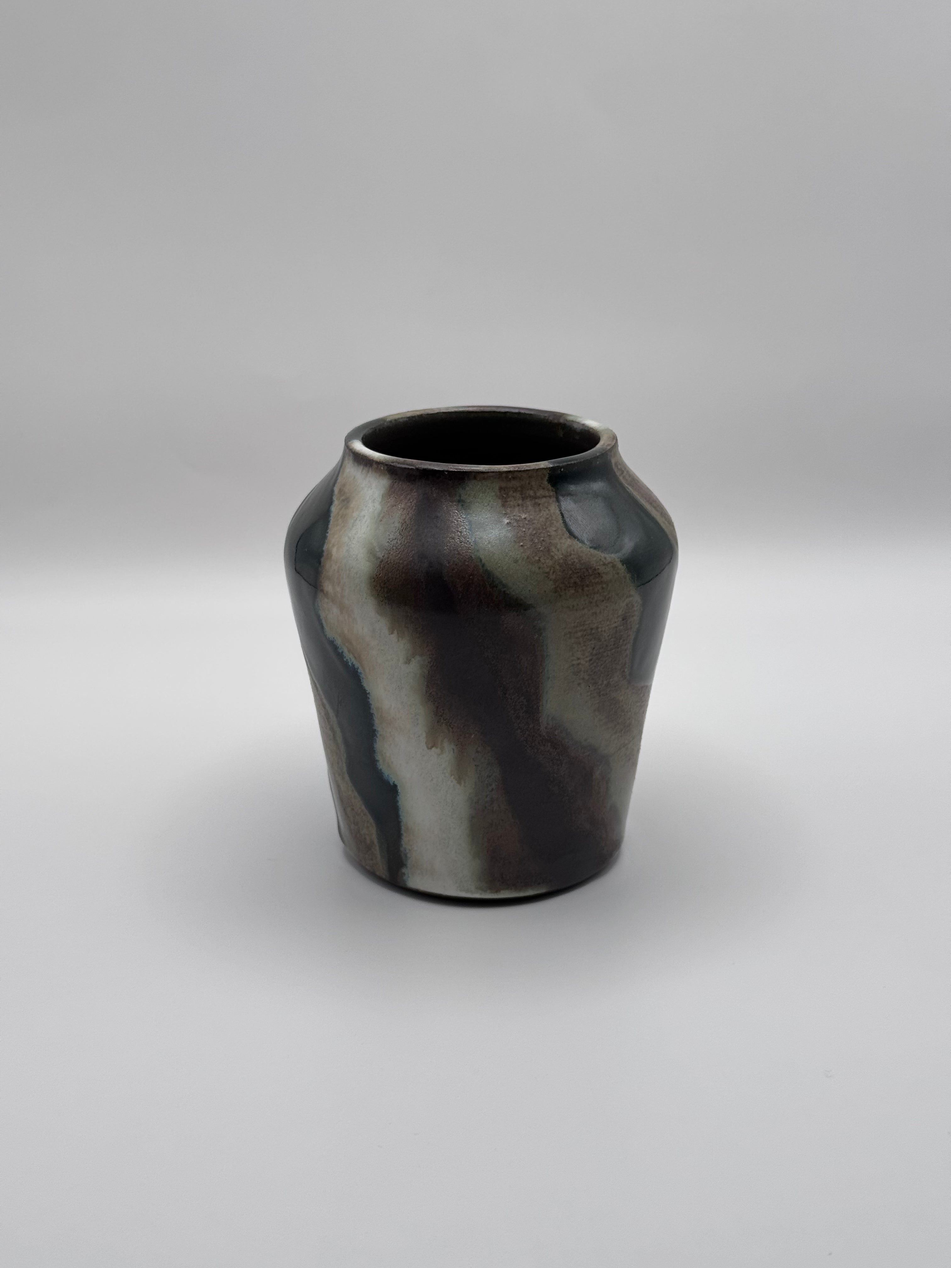 Tall ceramic vase with a defined shoulder and wide mouth, vertical streaks of dark brown, white, and green celadon glaze. View 1 of 3